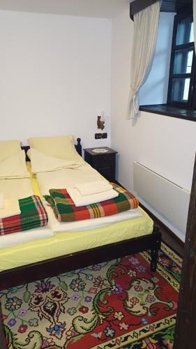 a bedroom with a bed with a colorful rug at Къща за гости -Абаджиевата къща in Kotel