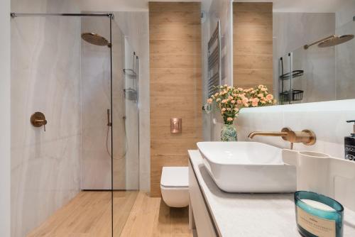 a bathroom with a toilet and a sink and a shower at Sol Marina Resort Wyspa Sobieszewska I - LoftAffair Collection in Wiślinka