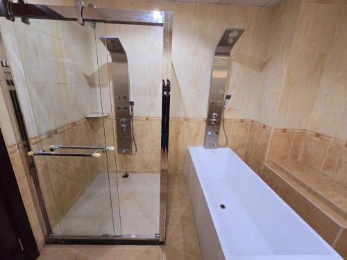 a bathroom with a shower with a tub and a sink at Stay House in Dubai in Dubai
