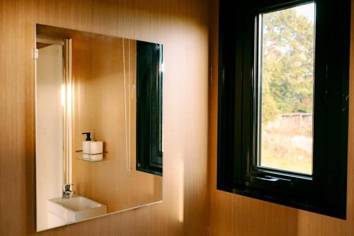 a bathroom with a mirror and a sink and a window at Rimu View 2 in Ruatapu