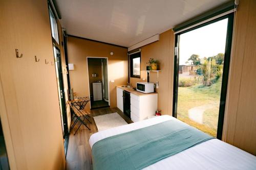 a bedroom with a bed and a large window at Rimu View 2 in Ruatapu