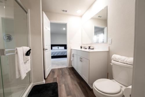 a white bathroom with a toilet and a sink at Charming Home near Seaworld in Helotes
