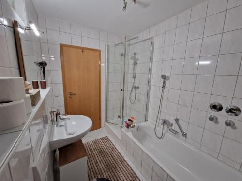 uma casa de banho com um chuveiro, uma banheira e um lavatório. em Maisonette Ferienwohnung am Kurpark em Bad Abbach