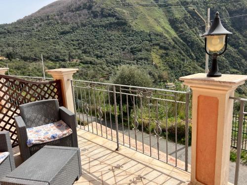 a balcony with a chair and a lamp and a mountain at La Marinella in Palmi