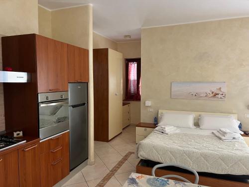 a bedroom with a bed and a kitchen with a stove at Residence La Marinella in Palmi