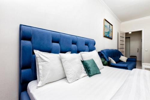 cabecero azul de una cama con almohadas blancas en Luxurious apartment in the heart of Astana, en Astana