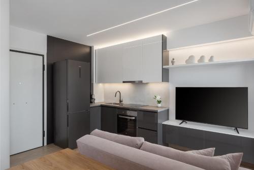 a living room with a couch and a kitchen at Athenian Riviera Seaside Suite in Athens