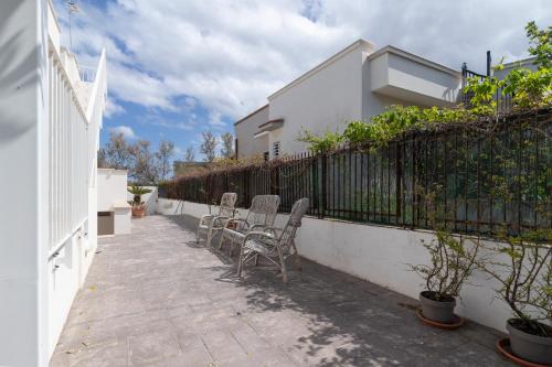 a patio with two chairs and a fence at Rossella House in Mola di Bari