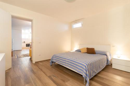 a white bedroom with a bed and a window at Rossella House in Mola di Bari