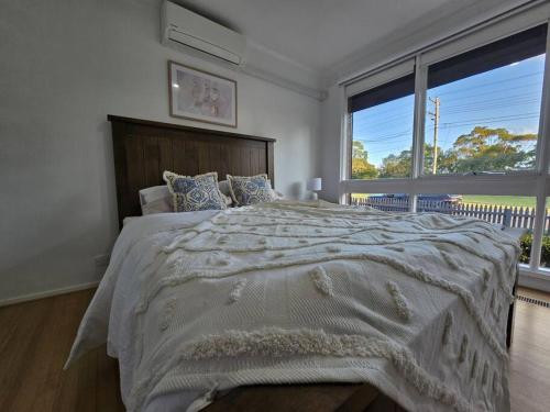 sypialnia z dużym łóżkiem i dużym oknem w obiekcie Meadow View Cottage w mieście Doveton