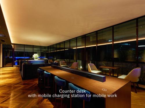 a lobby with a computer desk with mobile charging station for mobile work at Mitsui Garden Hotel Osaka Premier in Osaka