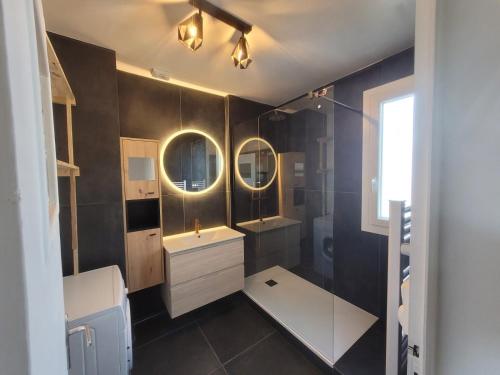 La salle de bains est pourvue d'une douche, d'un lavabo et d'un miroir. dans l'établissement Maison familiale, quartier calme, au Mans