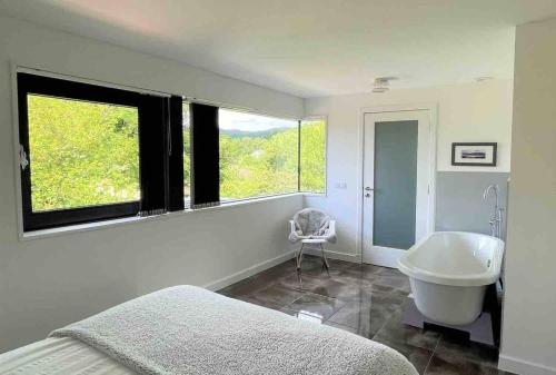 a bedroom with a tub and a sink and a window at Keppochhill - Beautiful Home with Hot Tub in Dullatur