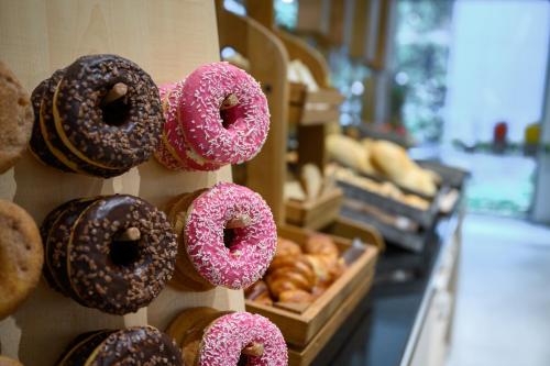Ein Haufen Donuts auf einem Regal in einer Bäckerei. in der Unterkunft Hilton Garden Inn Budapest City Centre in Budapest