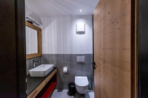 a bathroom with a white sink and a toilet at Rifugio Crëp de Munt in Corvara in Badia
