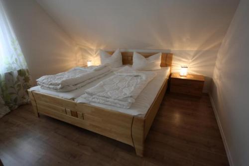 ein Schlafzimmer mit einem Bett mit zwei Leuchten in der Unterkunft K 95 - Modernes Ferienhaus mit Kamin in Roebel an der Mueritz in Marienfelde