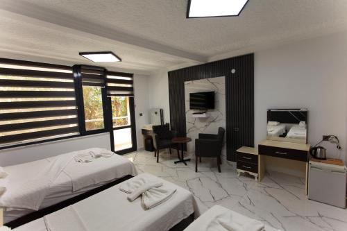 a hotel room with two beds and a desk and a mirror at Green Peace Hotel in Oludeniz