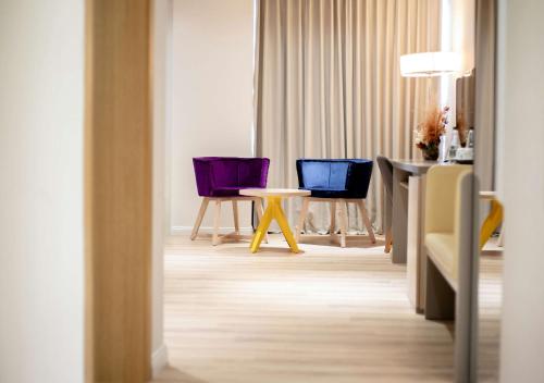 a room with two purple chairs and a table at Best Western Premier Ark Hotel in Tirana