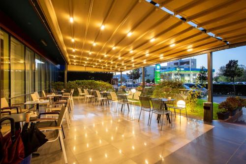 a restaurant with tables and chairs with lights on it at Best Western Premier Ark Hotel in Tirana