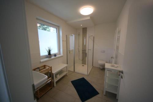 a bathroom with a tub and a sink and a shower at K 100 EG - Ferienwohnung im Erdgeschoss mit großem Garten in Röbel