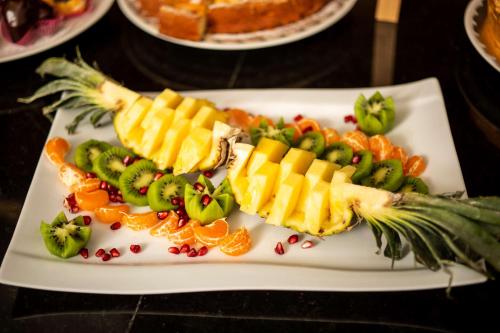a white plate with fruits and vegetables on a table at Best Western Premier Ark Hotel in Tirana