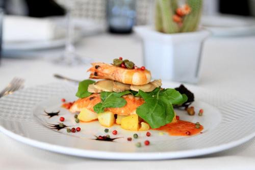 a white plate with a dish of food on a table at Best Western Premier Ark Hotel in Tirana
