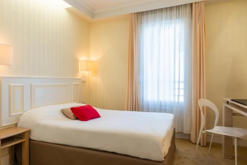 a hotel room with a bed and a window at The Originals City, Hôtel Chantecler, Le Mans in Le Mans