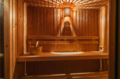 a wooden sauna with a bucket on a shelf at Dormio Villapark Duynzicht in Julianadorp