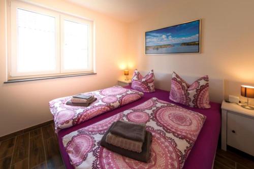 um quarto com 2 camas e lençóis cor-de-rosa em U12 EG - Charmante Ferienwohnung am See mit Kamin in Röbel an der Müritz em Marienfelde