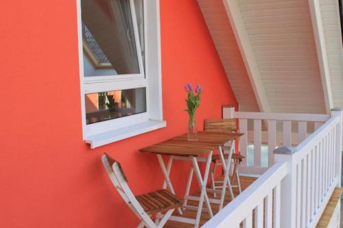 een tafel en stoelen op een veranda met een raam bij K 104 OG - stilvolle Ferienwohnung am See mit Balkon & Sauna in Röbel an der Müritz in Marienfelde