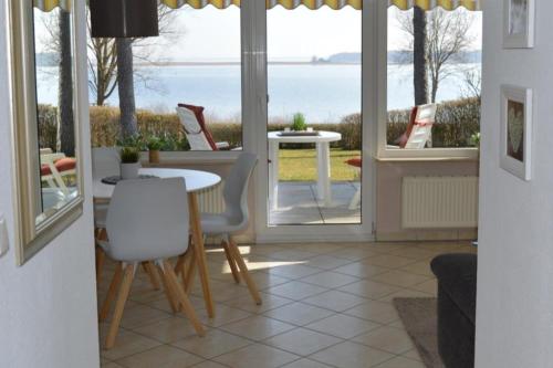 a dining room with a view of the ocean at 7 EG - Charmante Ferienwohnung mit Seeblick & schoenem Garten in Röbel an der Müritz in Marienfelde