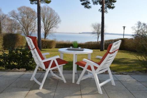 dos sillas y una mesa blanca y una mesa y sillas en 7 EG - Charmante Ferienwohnung mit Seeblick & schoenem Garten in Röbel an der Müritz en Marienfelde