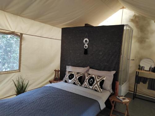 - une chambre avec un lit dans une tente dans l'établissement Glamping Casa Soarelui, à Vama Veche