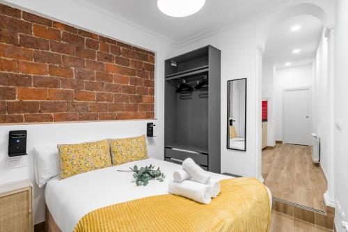 a bedroom with a bed and a brick wall at Charming Chueca Center in Madrid