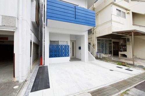 an empty courtyard of a building with blue doors at Lana Condo Naha in Naha