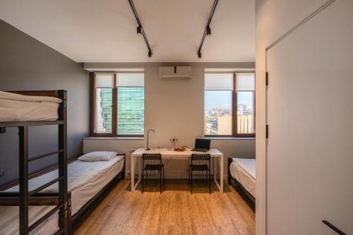 a room with two bunk beds and a desk with a laptop at Kantar Hostel in Yerevan