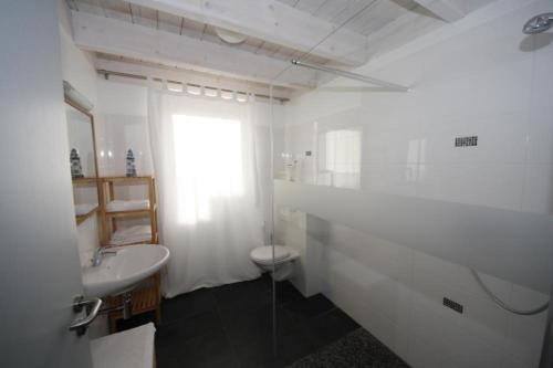 La salle de bains blanche est pourvue d'un lavabo et de toilettes. dans l'établissement W9 - Traumhaftes Ferienhaus mit Kamin & grossem Garten in Roebel, à Marienfelde