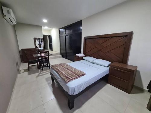 1 dormitorio con 1 cama grande y cabecero de madera en Casa vacacional Rafaela, en Ciudad Valles