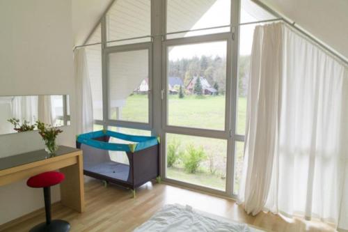 een kamer met een bureau en een groot raam bij W8 - wundervolles Ferienhaus in der Natur in Röbel an der Müritz in Röbel