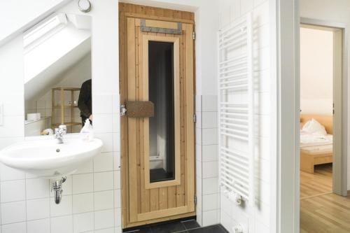 een badkamer met een wastafel en een spiegel bij W8 - wundervolles Ferienhaus in der Natur in Röbel an der Müritz in Röbel