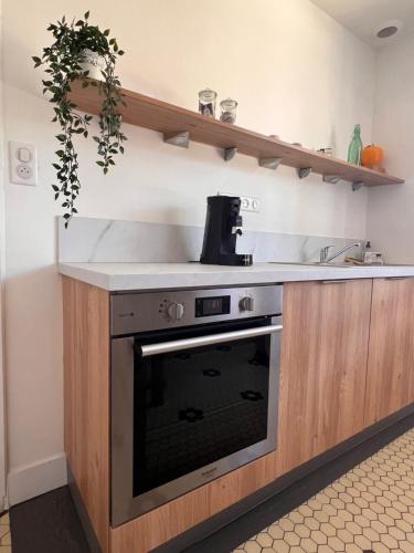 une cuisine avec une cuisinière et un évier dans l'établissement A 30 min de l'île aux Mimosa Maison Vendéenne avec Jardin, à Sallertaine