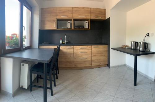 una cocina con armarios de madera y una mesa con sillas. en Nicolsburg, en Mikulov