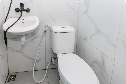 La salle de bains est pourvue de toilettes et d'un lavabo. dans l'établissement OYO 93772 Iconiq Rooms, à Bekasi