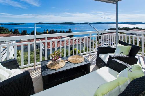 a balcony with chairs and tables and a view of the ocean at Apartmani Zora in Hvar