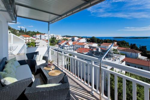 a balcony with chairs and a view of the water at Apartmani Zora in Hvar
