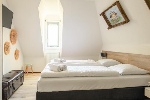 a bedroom with a bed with towels on it at Dormio Villapark Duynzicht in Julianadorp