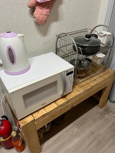 a microwave sitting on top of a wooden shelf at Sam Apartment in Goyang