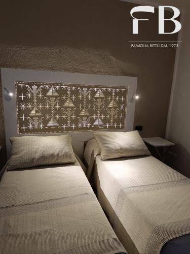 two beds sitting next to each other in a bedroom at Albergo Da Bittu in Samughèo