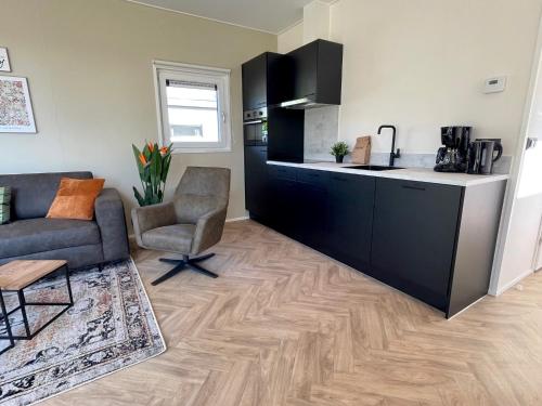 a living room with a kitchen and a couch and a table at Vakantiepark Bergsehaak in Haaksbergen
