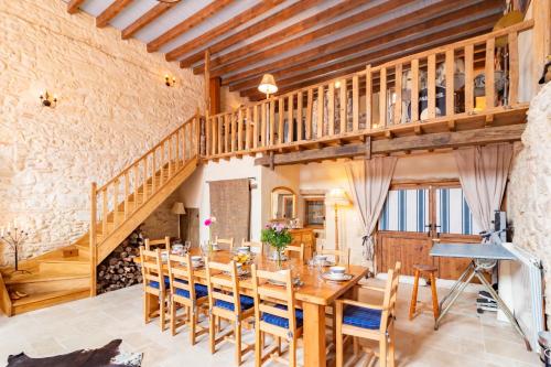 une salle à manger avec une table et des chaises en bois dans l'établissement La Maison 1786 - Grand jardin et jacuzzi, à Mansonville